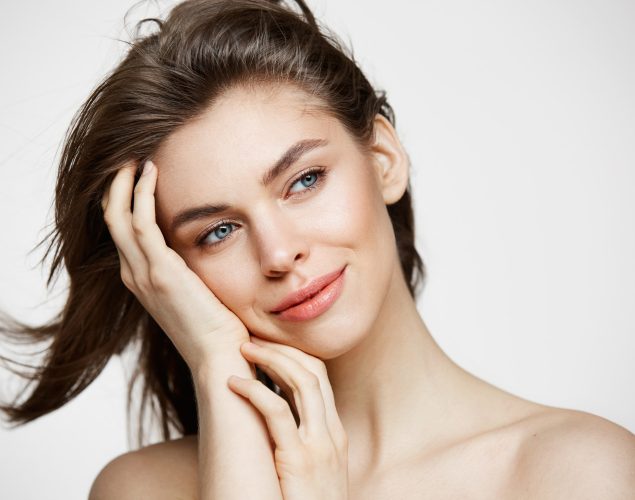 beautiful-naked-young-woman-with-perfect-clean-skin-smiling-touching-hair-over-white-wall-facial-treatment